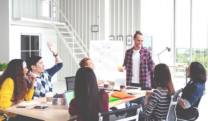 A creative team actively brainstorming and discussing in a bright office space.