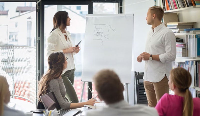 A team discussing ideas while seated around a table in a well-lit office.